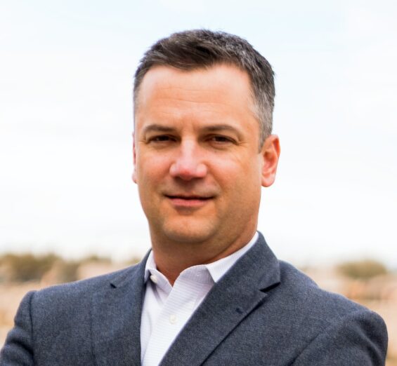 Businessman in dark gray suit and white button down shirt posing for a professional headshot | Scott Bedell, President & CEO, Caltrol, Inc.